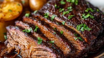 Juicy slow cooker brisket sliced with rich gravy, served with roasted vegetables.