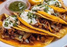 Authentic quesabirria tacos filled with tender beef birria, melted cheese, and fresh cilantro, served with a side of consommé for dipping.