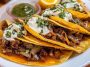 Authentic quesabirria tacos filled with tender beef birria, melted cheese, and fresh cilantro, served with a side of consommé for dipping.
