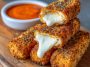Golden crispy buffalo chicken mozzarella sticks served with ranch dipping sauce and sprinkled with fresh parsley.