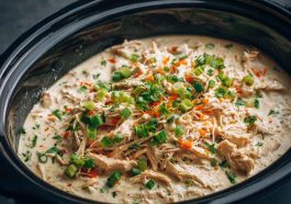 “Creamy ranch chicken cooked in a crock pot, served over rice with fresh parsley garnish.”