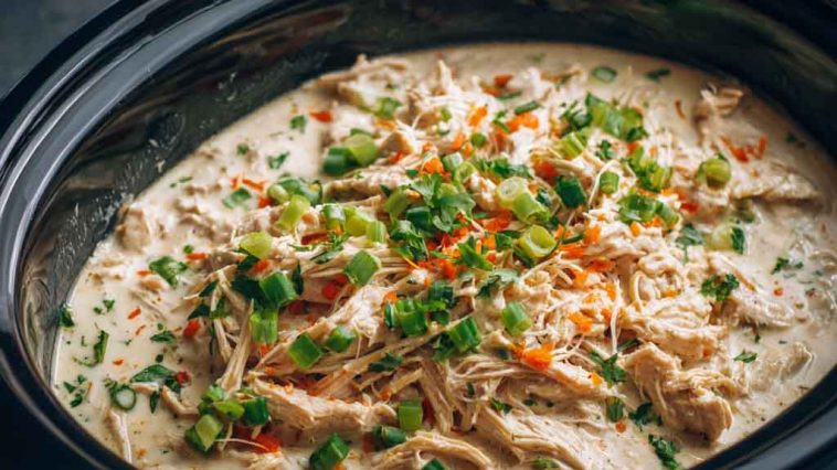 “Creamy ranch chicken cooked in a crock pot, served over rice with fresh parsley garnish.”