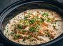 “Creamy ranch chicken cooked in a crock pot, served over rice with fresh parsley garnish.”