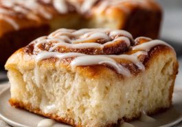 Golden cinnamon roll focaccia topped with icing drizzle on a baking tray