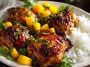 Asian mango glazed chicken coated in a glossy sweet and savory sauce, garnished with herbs and sesame seeds.