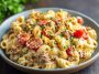 A hearty skillet of creamy loaded cheeseburger Alfredo pasta topped with melted cheese, ground beef, crispy bacon, and fresh parsley.