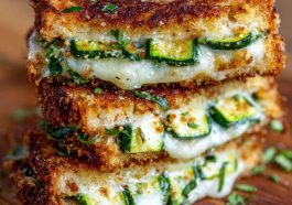 Crispy grilled cheese sandwich with zucchini slices and garlic butter, melted cheese inside.