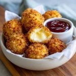 Air fried Babybel cheese with a crispy golden coating and melted cheese center.