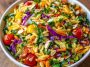 Colorful orzo salad with fresh vegetables in a light, zesty dressing.