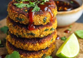 Healthy sweet potato lentil patties golden and crispy on the outside, served with a dipping sauce and fresh herbs.