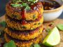 Healthy sweet potato lentil patties golden and crispy on the outside, served with a dipping sauce and fresh herbs.