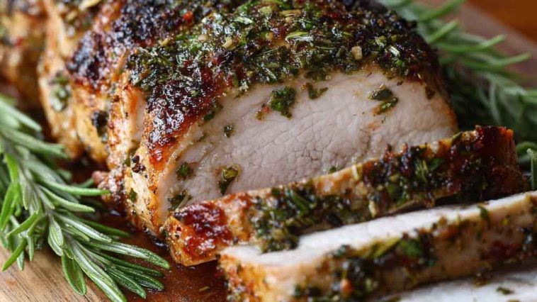 Herb crusted pork loin roast sliced and served with a golden crust and juicy interior.