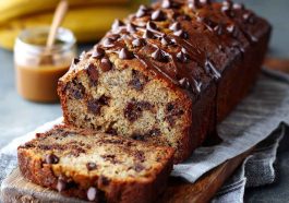 Moist chocolate chip banana bread with sliced bananas and melted chocolate chips throughout.