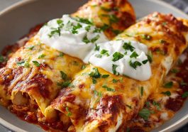 Creamy chicken enchiladas baked with melted cheese and rich sauce in a casserole dish.
