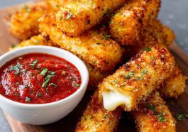 Crispy mozzarella sticks with marinara dipping sauce on a plate