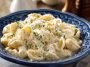 A creamy bowl of fettuccine pasta topped with cottage cheese Alfredo sauce, garnished with fresh parsley and grated Parmesan.