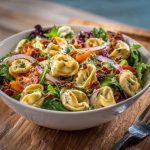 Tortellini salad with grinder toppings and creamy dressing in a bowl
