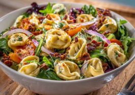 Tortellini salad with grinder toppings and creamy dressing in a bowl