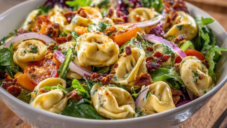 Tortellini salad with grinder toppings and creamy dressing in a bowl