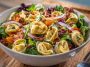 Tortellini salad with grinder toppings and creamy dressing in a bowl
