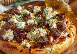 Crispy pizza topped with sausage, ricotta cheese, melted cheese, and drizzled with hot honey.