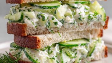 Fresh cucumber salad sandwiches with cream cheese and herbs on a plate.