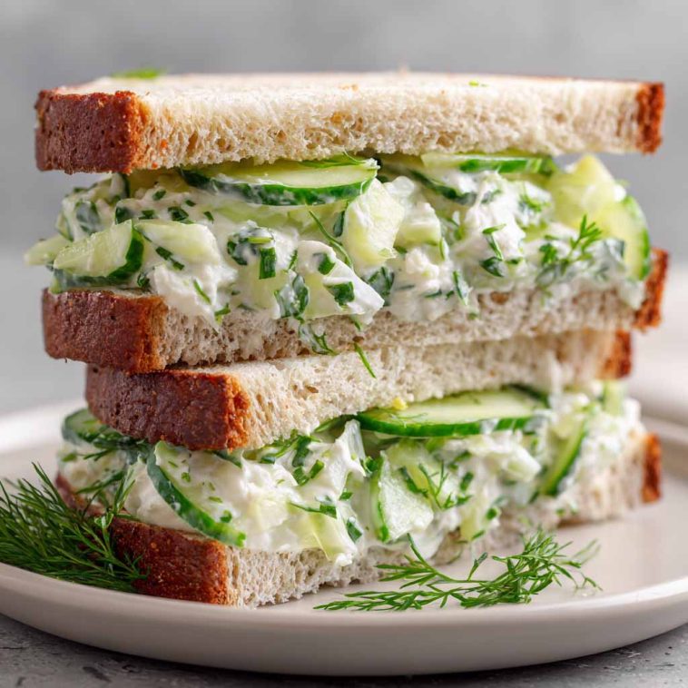 Fresh cucumber salad sandwiches with cream cheese and herbs on a plate.