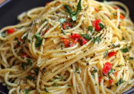 A rustic plate of Italian pasta tossed in garlic olive oil sauce, garnished with fresh parsley and Parmesan cheese, served with crusty bread.