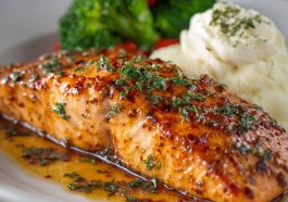 Grilled salmon fillet glazed with a sweet and savory sauce, served with lemon and herbs.