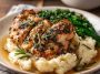 Garlic herb chicken served with creamy mashed potatoes and a rich, savory sauce.