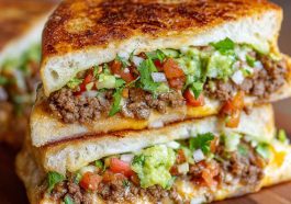 Toasted sandwich filled with seasoned ground beef, melted cheese, and fresh toppings.