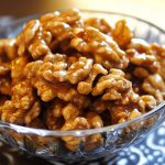 Crunchy caramel-coated walnuts glistening with a golden sugary glaze.
