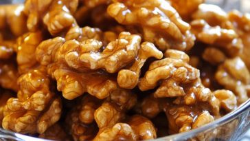 Crunchy caramel-coated walnuts glistening with a golden sugary glaze.