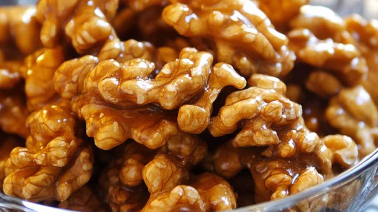 Crunchy caramel-coated walnuts glistening with a golden sugary glaze.