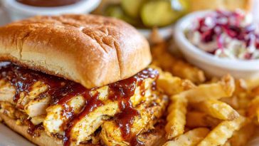 Chicken chopped sandwich with Alabama white BBQ sauce, served on a toasted bun with fresh toppings.