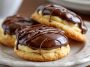Soft vanilla cookies filled with creamy pastry cream and topped with glossy chocolate glaze.