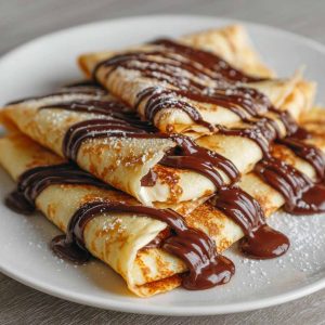 Thin crepes filled with melted chocolate, folded and topped with powdered sugar.