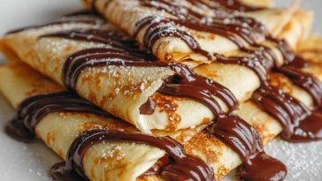 Thin crepes filled with melted chocolate, folded and topped with powdered sugar.