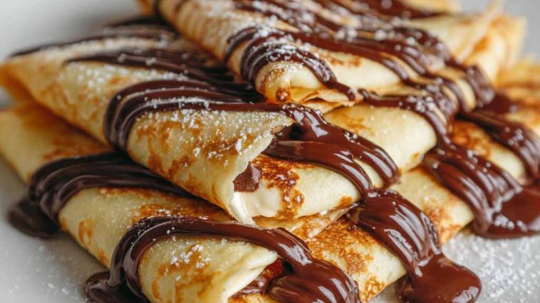 Thin crepes filled with melted chocolate, folded and topped with powdered sugar.