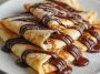 Thin crepes filled with melted chocolate, folded and topped with powdered sugar.
