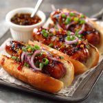 Firecracker hot dogs topped with spicy sauce and melted cheese