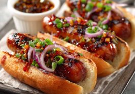 Firecracker hot dogs topped with spicy sauce and melted cheese