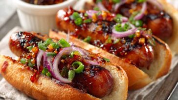 Firecracker hot dogs topped with spicy sauce and melted cheese