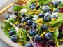 Fresh blueberry pistachio spring salad with mixed greens, vibrant berries, and crunchy nuts.