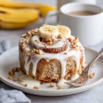 Soft banana bread cinnamon rolls swirled with cinnamon sugar and topped with creamy cream cheese frosting.