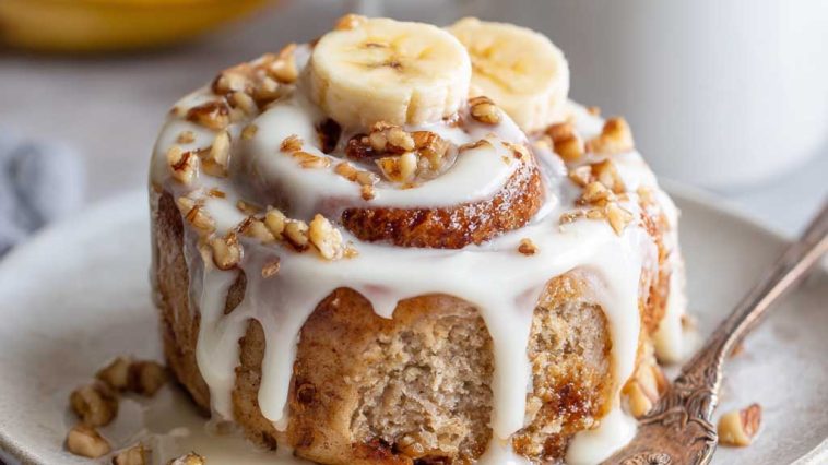 Soft banana bread cinnamon rolls swirled with cinnamon sugar and topped with creamy cream cheese frosting.