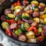 One-pan honey garlic kielbasa with roasted vegetables coated in a glossy sweet and savory sauce.