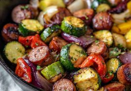 One-pan honey garlic kielbasa with roasted vegetables coated in a glossy sweet and savory sauce.