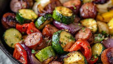 One-pan honey garlic kielbasa with roasted vegetables coated in a glossy sweet and savory sauce.