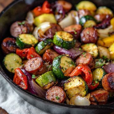 One-pan honey garlic kielbasa with roasted vegetables coated in a glossy sweet and savory sauce.